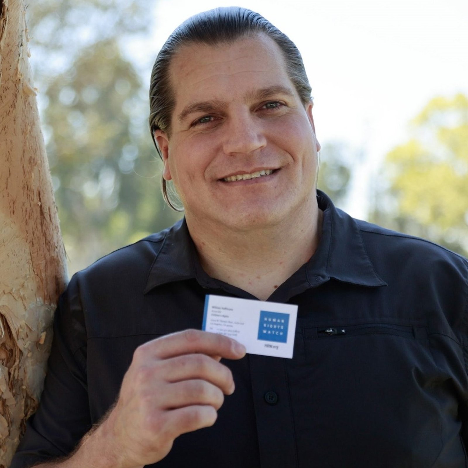 An image of a person formerly sentenced to LWOP holding up a business card.