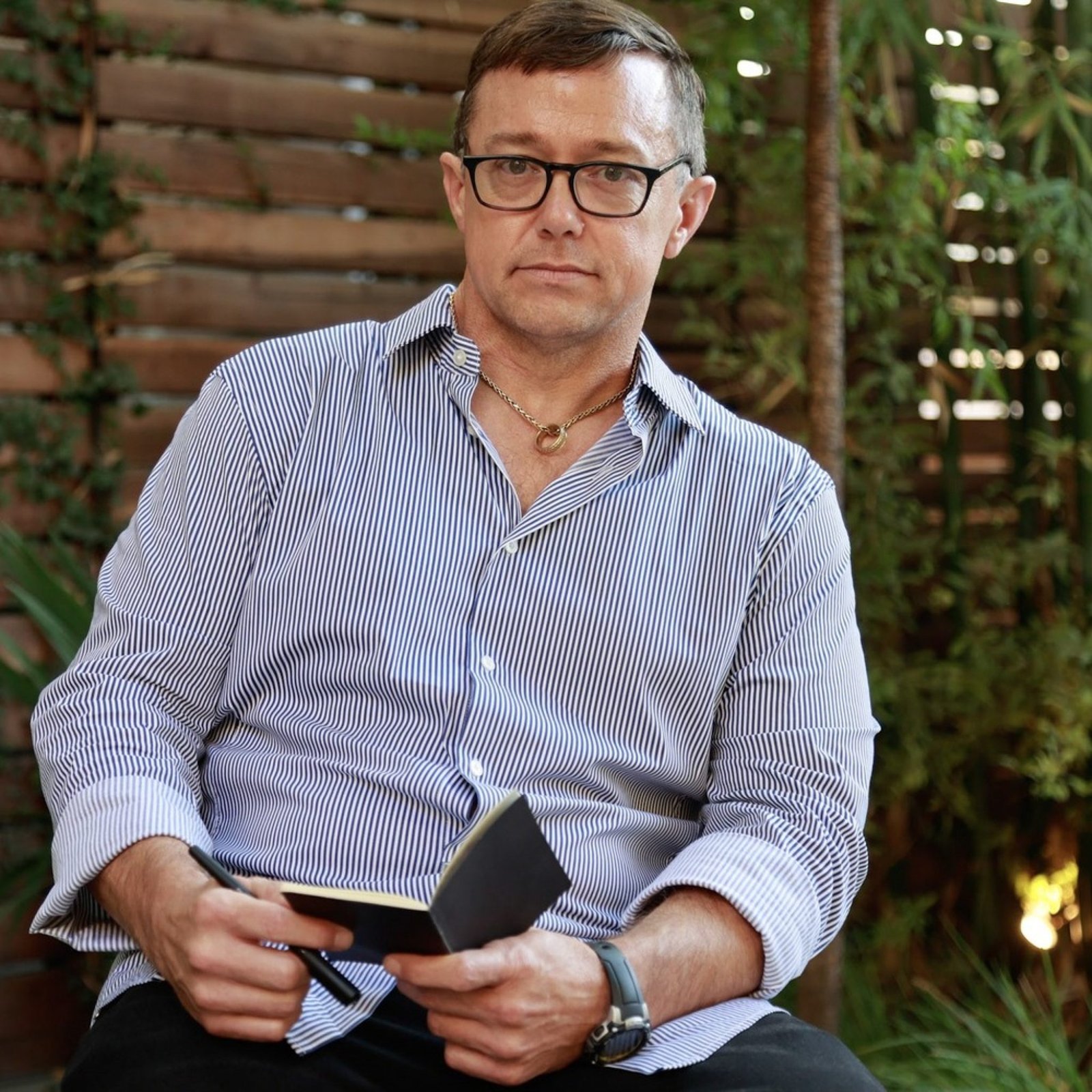 An image of a person formerly sentenced to LWOP holding a notebook and pen.
