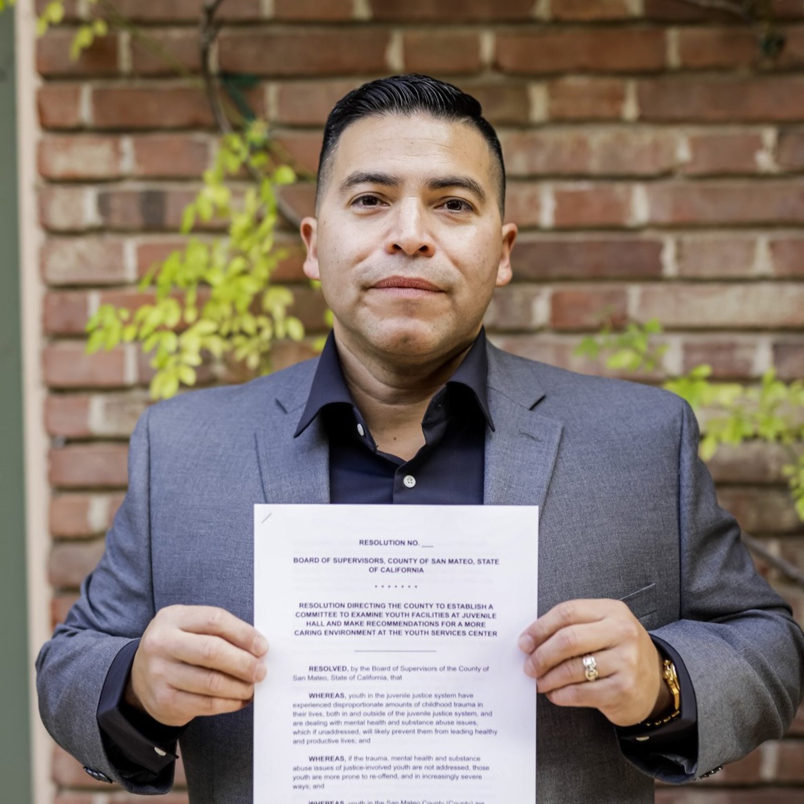 An image of a person formerly sentenced to LWOP holding a legislative document.